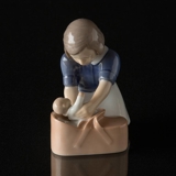 Mädchen liegt sanft die Puppe in den Korb, Bing & Gröndahl Figur Nr. 2307