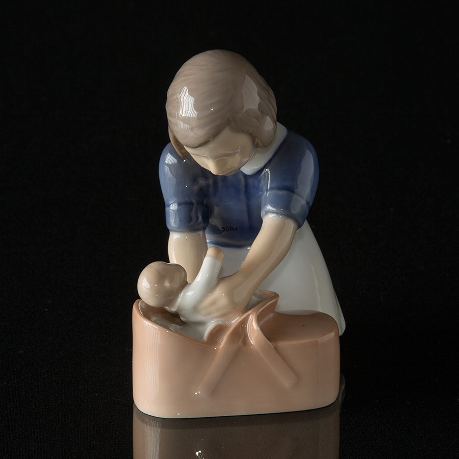 Mädchen liegt sanft die Puppe in den Korb, Bing & Gröndahl Figur Nr. 2307