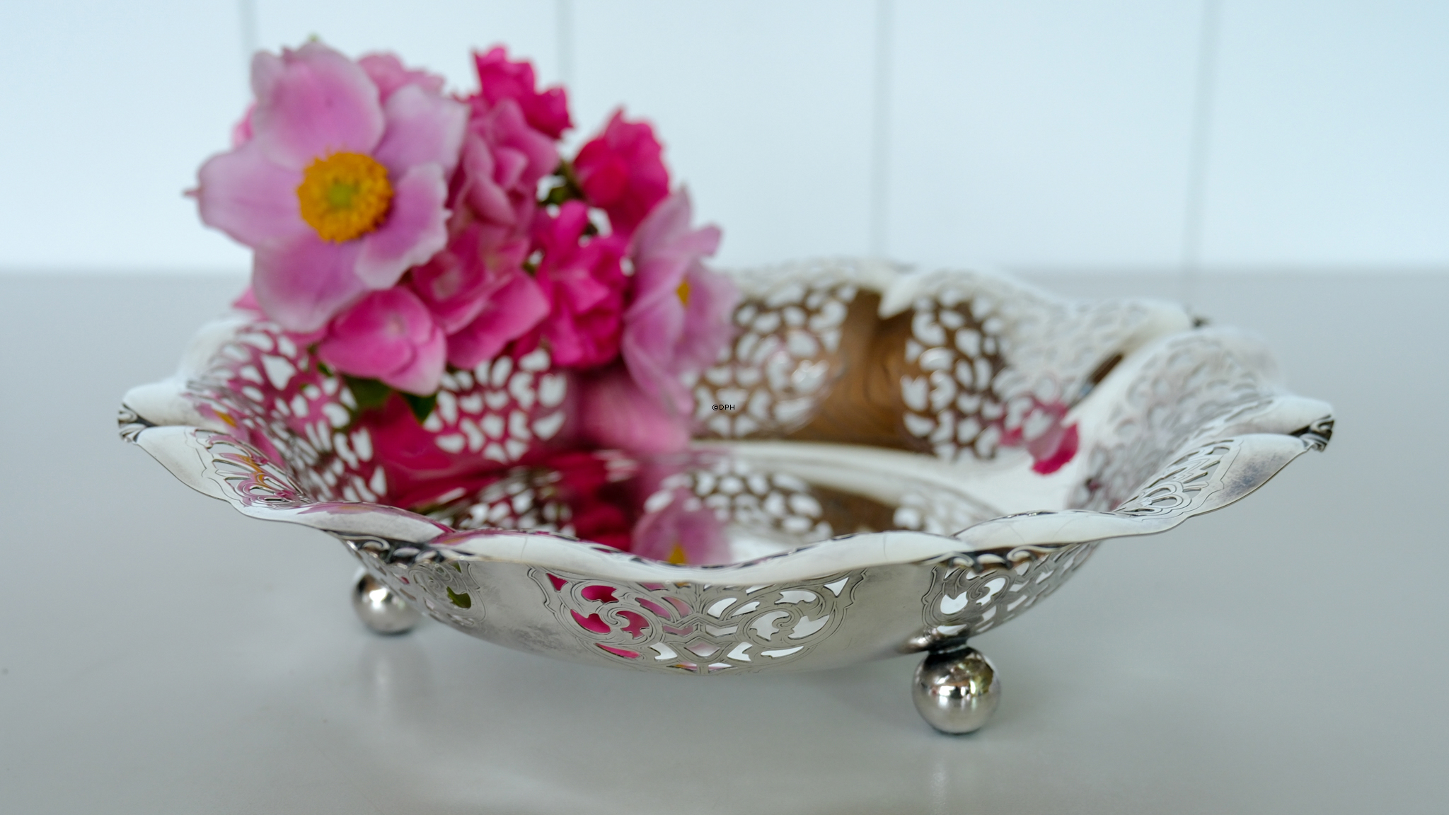 Schale in Silberfinish mit Blumendekoration und Gebrauchsspuren