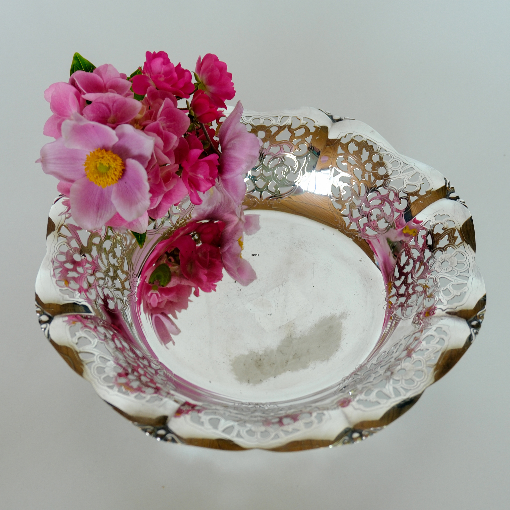 Schale in Silberfinish mit Blumendekoration und Gebrauchsspuren