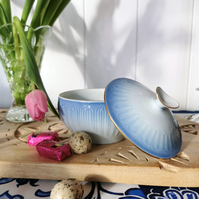 Bing & Gröndahl Ballerina Zuckerschale in Blau- und Weißtönen mit Goldrand. Präsentiert auf einem Holztablett mit einer Tulpe, Schokolade und Ostereiern.