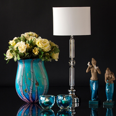 Blaue Glasvase mit Teelichthaltern und Lampe mit zwei Figuren