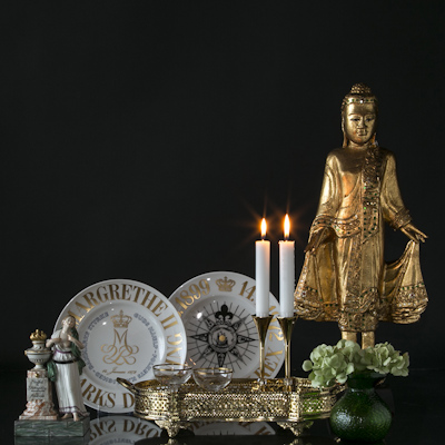 Buddha flankiert von Gedenktellern und Freundschaftsfigur hinter einem Tablett mit Asmussen Kerzenhaltern