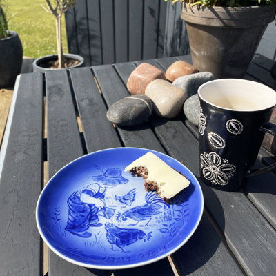 Alltägliches Frühstück, serviert auf einem blauen Désirée Muttertagsteller mit Motiv. Aufbau im Freien auf einem Gartentisch.