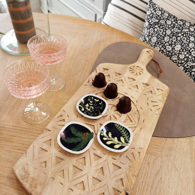 Rörstrand Blumen-Miniteller, verwendet als kleine Schälchen zum Servieren von Schokolade, angerichtet auf einem Holzbrett mit Roséwein in Gläsern.