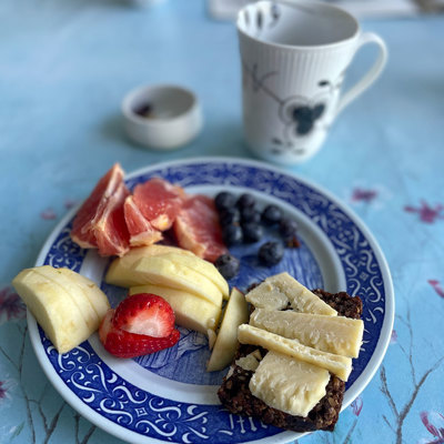 Rörstrand Muttertagsteller, verwendet als Frühstücksteller mit Obst, Roggenbrot mit Käse und Kaffee. Ein Beispiel dafür, wie blaue Teller im Alltag verwendet werden können.