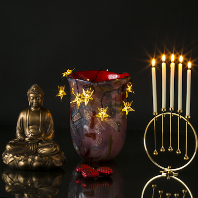 Großer Buddha zusammen mit roter Glasvase und Asmussen Kerzenhaltern auf rundem Tablett