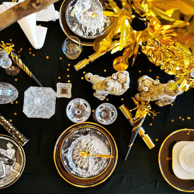 Silvestertafel in Schwarz, Weiß und Gold mit Rörstrand Tellern aus der Zehn-Gebote-Serie und Orrefors Jahresglastellern. Schöne Trinkgläser, festliche Dekorationen und goldene Details vervollständigen die Tischdekoration.